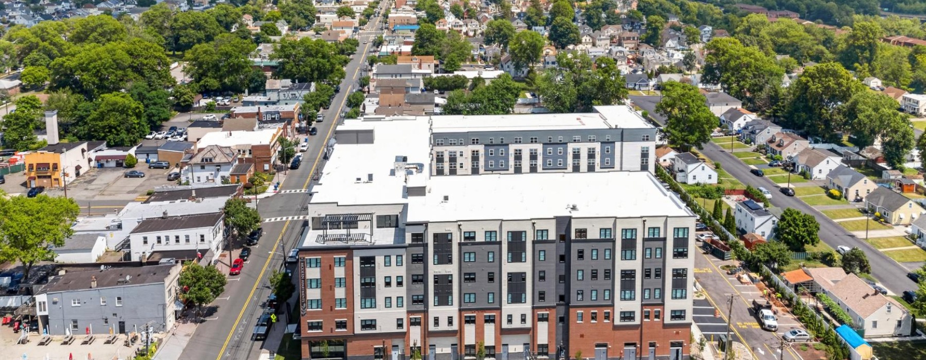 A large residential building surrounded by small homes and greeneries