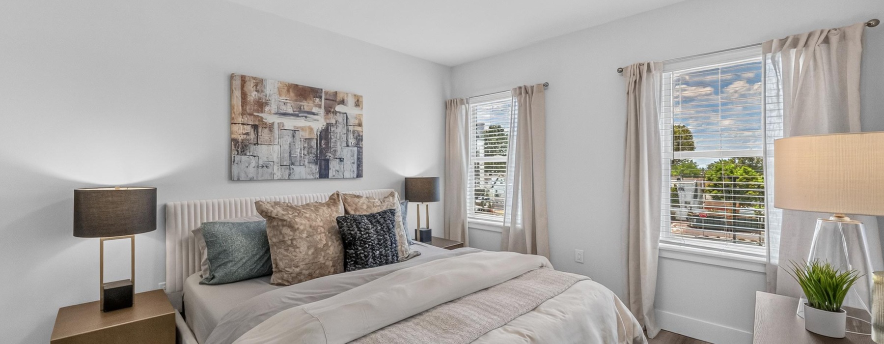 Bedroom with bed, night stands, and airy windows