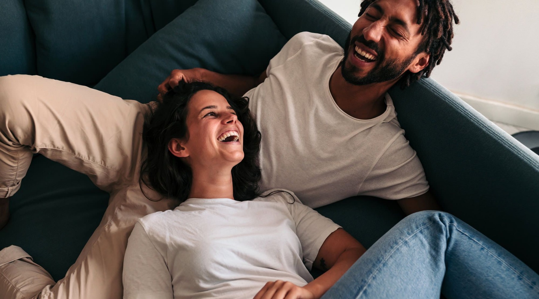 a couple laughing on a couch