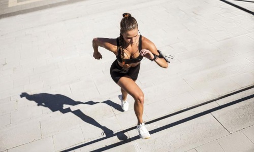 woman exercises running outside up stairs